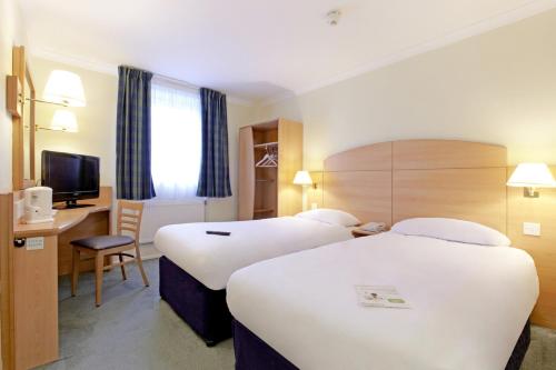 a hotel room with two beds and a television at Campanile Hotel Glasgow SECC Hydro in Glasgow