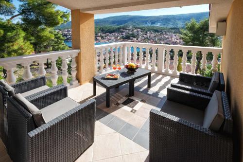 a dining room table with chairs and a balcony at Villa Vista in Jelsa