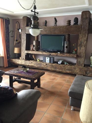 a living room with a tv and a couch and a table at Ferienwohnungen Maria Ginther in Pinswang