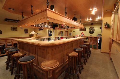 a bar with a bunch of stools around it at Hotel-Restaurant Alpina in Innertkirchen