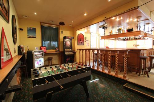 a room with a foosball table in front of a bar at Hotel-Restaurant Alpina in Innertkirchen