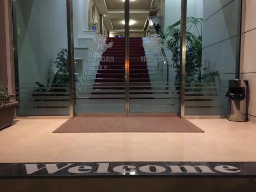 a welcome sign in front of a building at Herges Hotel in Durrës