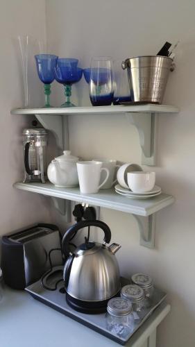 a tea kettle on a shelf in a kitchen at Bergview Guesthouse Swellendam in Swellendam