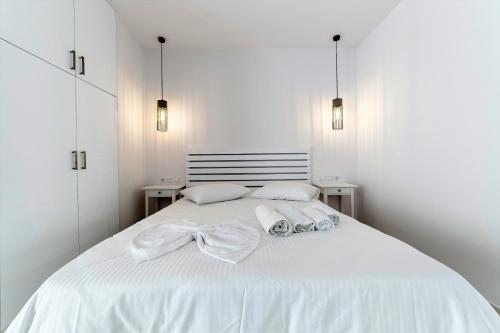 a white bed with two pillows and a bow on it at Liberte Maisonettes in Parga