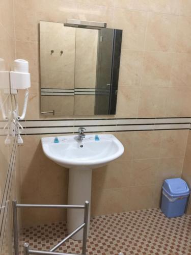 a bathroom with a sink and a mirror at Herges Hotel in Durrës