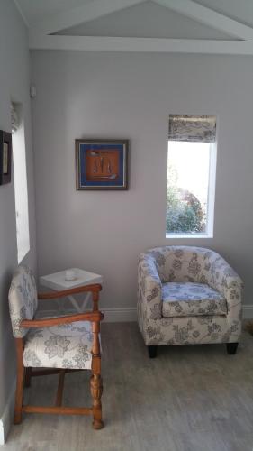 a living room with a couch and a chair at Bergview Guesthouse Swellendam in Swellendam