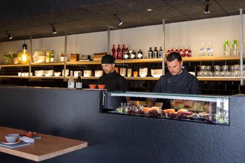 two men standing behind a counter in a restaurant at Altafulla Mar Hotel in Altafulla