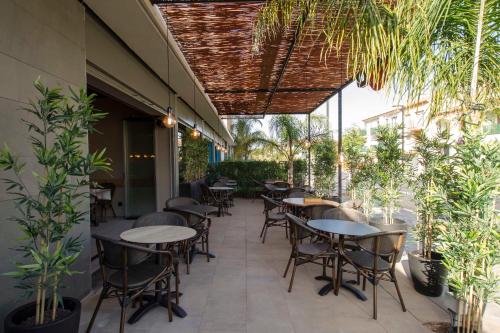 an outdoor patio with tables and chairs and plants at Altafulla Mar Hotel in Altafulla