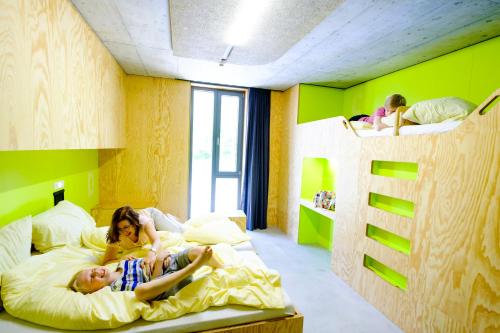 two children laying on a bed in a bedroom at Jugendherberge Bayreuth in Bayreuth