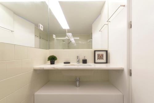 uma casa de banho com um lavatório e um espelho em LovelyStay - Top Floor Balcony Apartment no Porto