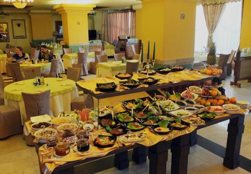 um buffet de comida nas mesas de um restaurante em Hotel Central em Ploieşti