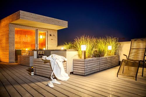 a deck with a table and chairs and a house at Hotel & Restaurant Heyligenstaedt in Gießen