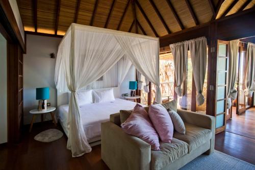a bedroom with a canopy bed and a couch at Sentidos Beach Retreat in Miramar