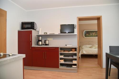 a kitchen with red cabinets and a refrigerator at Schlafen in Weimar in Weimar