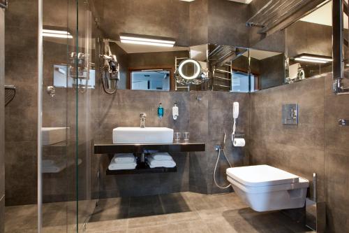 a bathroom with a sink and a toilet and a shower at Bayjonn Boutique Hotel in Sopot