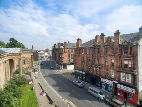 a city street with buildings and cars on the road at Townhead Apartments Gallery View in Paisley