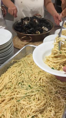 a person holding a plate of spaghetti on a table at Albergo Villa Mario in Ischia