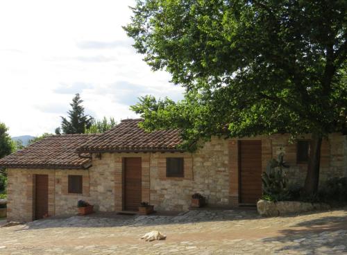 a brick house with a tree in front of it at Agriturismo Casale delle Lucrezie in Todi