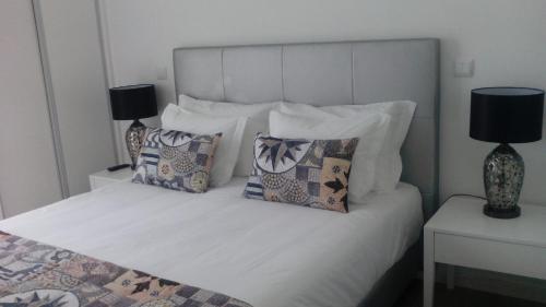 a bedroom with a white bed with pillows at Pico Dreams in São Roque do Pico