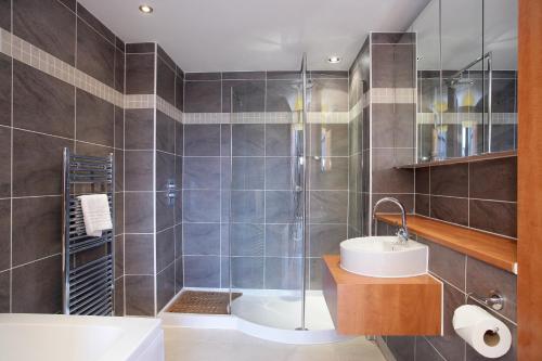 a bathroom with a shower and a sink and a tub at Kepplestone Manor in Aberdeen