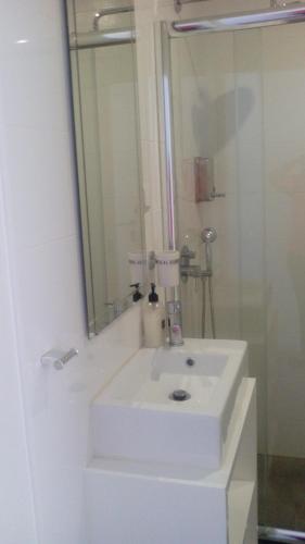 a bathroom with a white sink and a mirror at Pico Dreams in São Roque do Pico