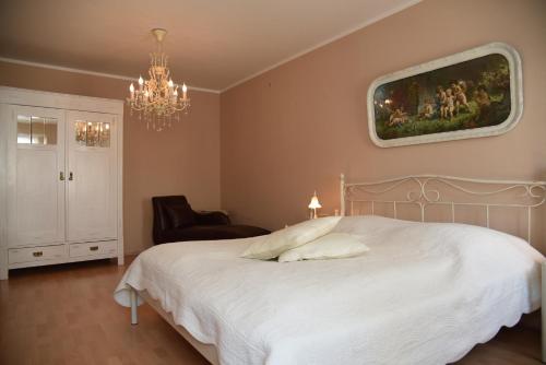a bedroom with a white bed and a chandelier at Schlafen in Weimar in Weimar