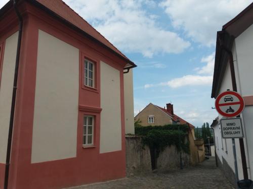a red and white building with a sign on a street at Villa Magdalena in Kutná Hora