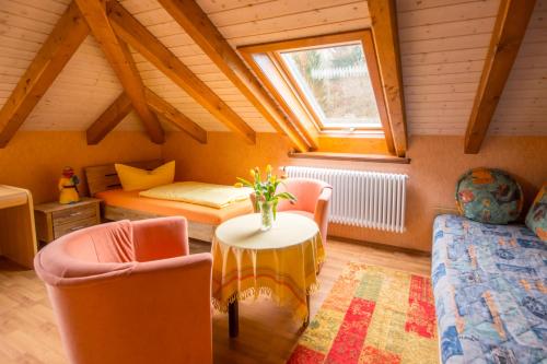 a attic room with a table and chairs and a bed at Ferienwohnungen Ender in Sebnitz