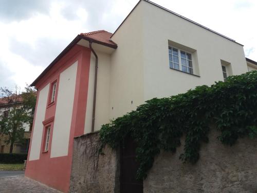 a white and red building next to a wall at Villa Magdalena in Kutná Hora