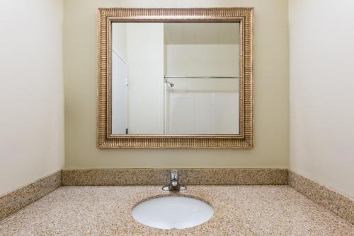 a bathroom with a mirror and a sink at Knights Inn Palmyra in Palmyra