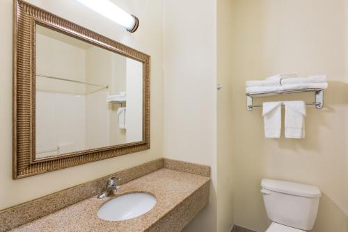 a bathroom with a sink and a mirror and a toilet at Knights Inn Palmyra in Palmyra