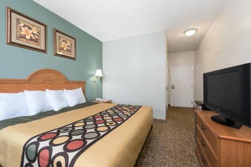 a hotel room with a bed and a flat screen tv at Knights Inn Palmyra in Palmyra