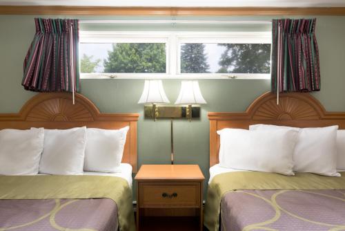 a hotel room with two beds and a window at Knights Inn Palmyra in Palmyra