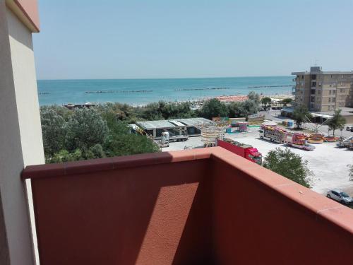 a balcony with a view of a parking lot and the ocean at Aurora Residence in Lido Adriano