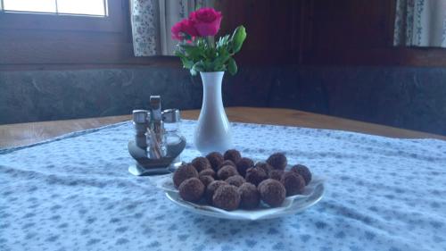 a plate of chocolate cookies on a table with a vase at Schwaighof in Oberau