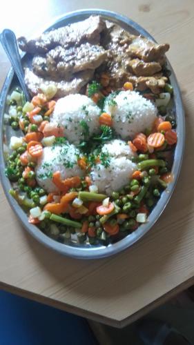 a plate of food with rice and vegetables on a table at Schwaighof in Oberau