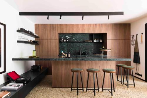 a kitchen with a bar with stools in it at Loft Living Garden Suite in Nieuwpoort