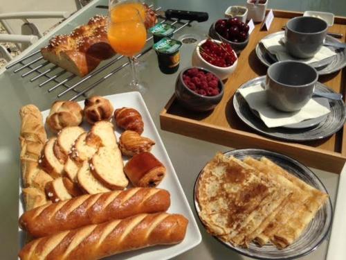 Montmorency-Beaufortにある"La Lavandière" climatisation Restauration Parking Privéのペストリーなどの朝食用食品をトッピングしたテーブル