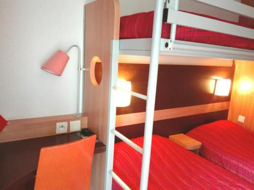 a bedroom with two bunk beds and a red bed at Premiere Classe Grenoble Sud - Gieres Universite in Gières
