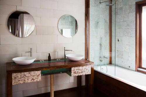 two sinks on a counter in a bathroom with a tub at Sentidos Beach Retreat in Miramar