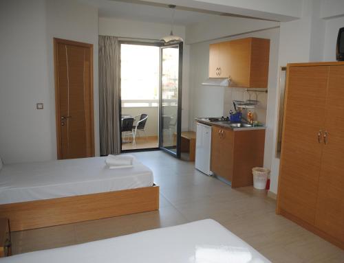 a large room with a bed and a kitchen at Niriides Studios and Apartments in Paralia Katerinis