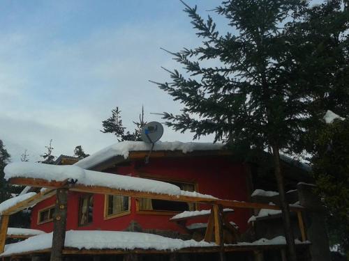 a house with a snow covered roof with a satellite at Del Viejo Camino in El Bolsón