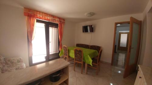 a small room with a green table and chairs at Apartmaji Katrč in Soča