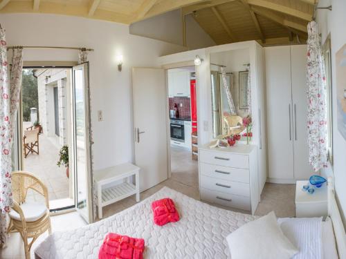 a bedroom with a white bed and a mirror at Villa Jiulita in Tsoukaladhes