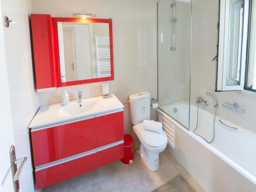 a bathroom with a red cabinet and a toilet and a sink at Villa Jiulita in Tsoukaladhes