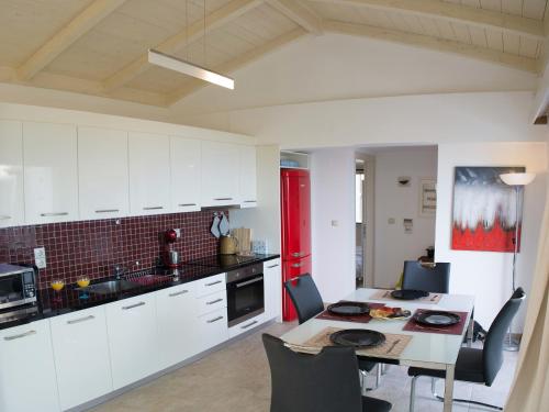 a kitchen with white cabinets and a table and chairs at Villa Jiulita in Tsoukaladhes