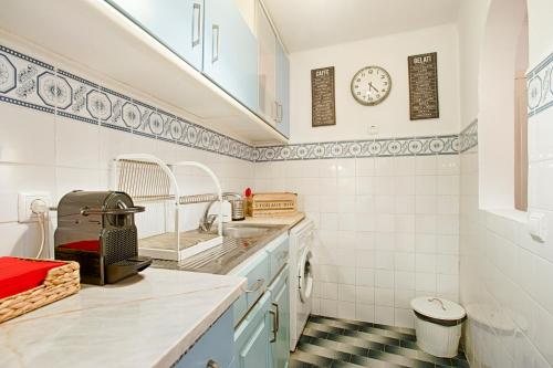 una cucina con lavandino e orologio sul muro di BmyGuest - Mouraria Central Apartment II a Lisbona