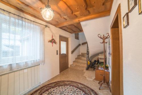 a hallway with a staircase and a window and a rug at Apartmenthaus Kometerhof in Flattach
