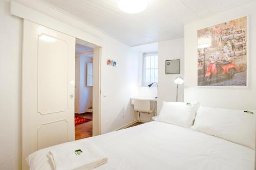 a white bedroom with a bed and a desk at BmyGuest - Mouraria Central Apartment II in Lisbon