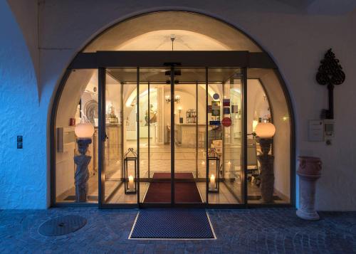 an entrance to a store with a large glass door at Boutique Hotel Sunstar Brissago am Lago Maggiore in Brissago